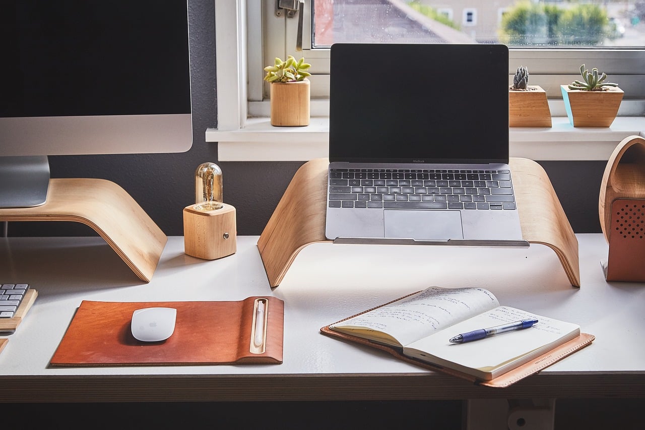 In foto, una scrivania con un computer e un'agenda.