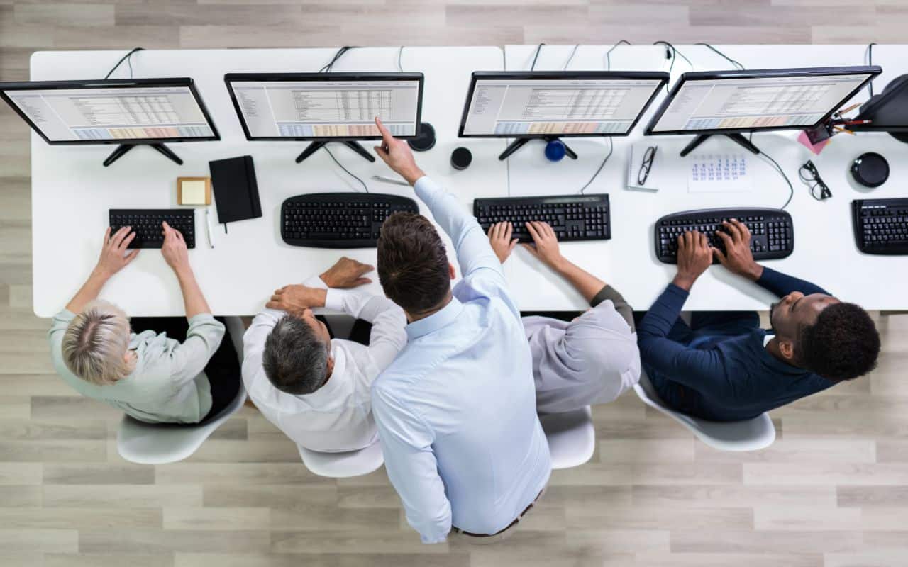 Formazione per operatori di call center: un istruttore guida un gruppo di agenti durante una sessione pratica al computer, focalizzata sul miglioramento delle competenze tecniche e operative.