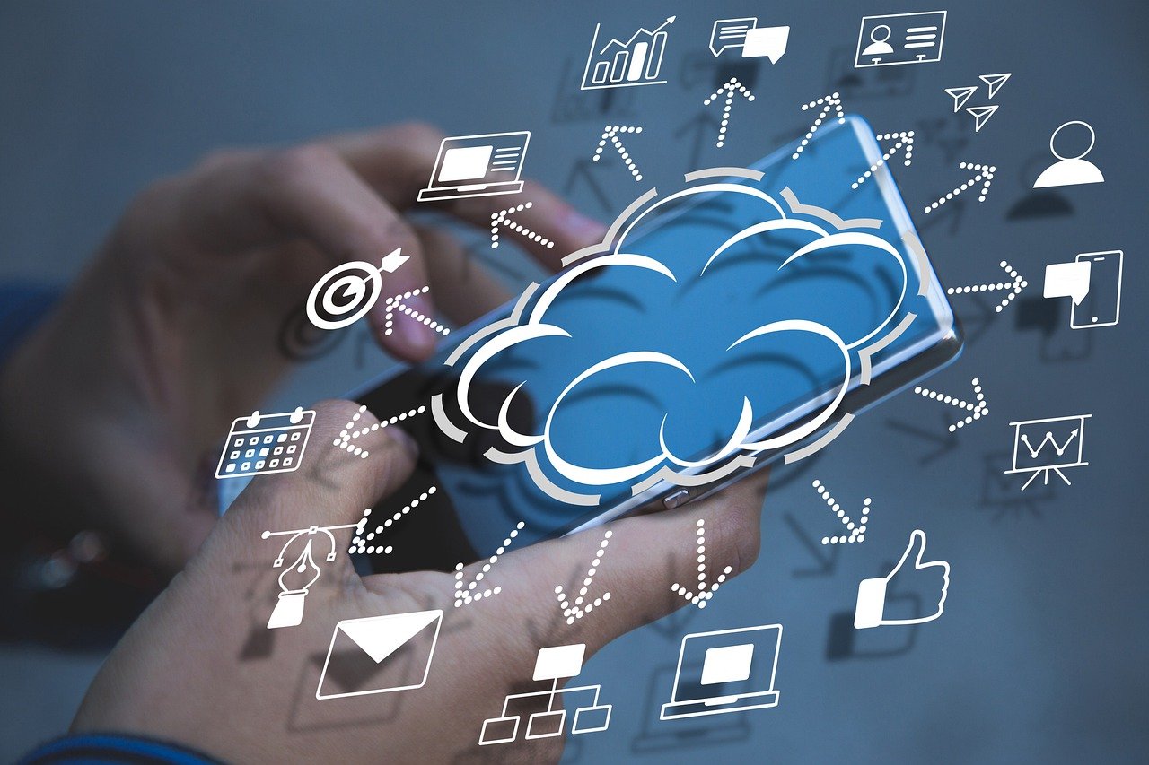 Mani che tengono uno smartphone con illustrazione di una nuvola digitale e icone collegate, rappresentando il cloud computing e la gestione dati in cloud.