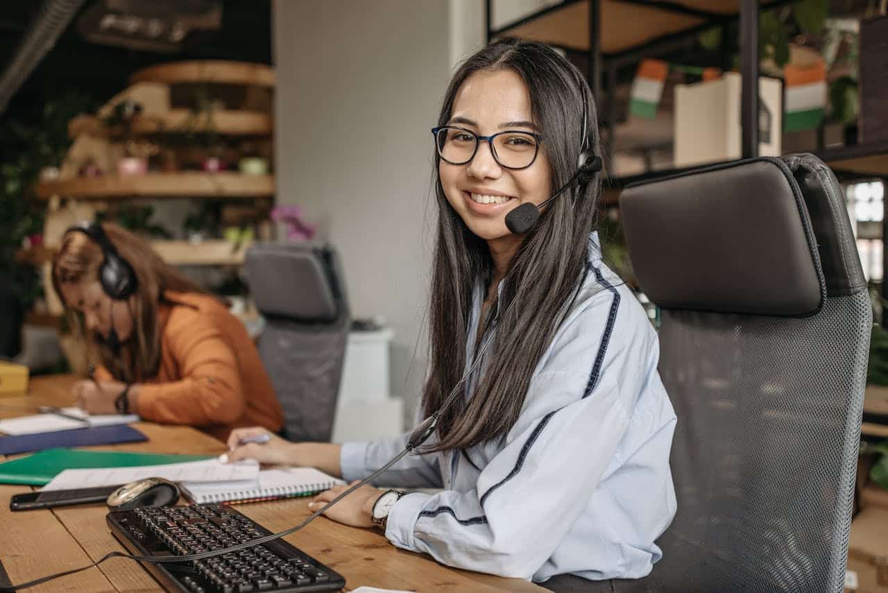 Operatrici di call center al lavoro con cuffie e computer in ufficio moderno, esempio di gestione turni efficace