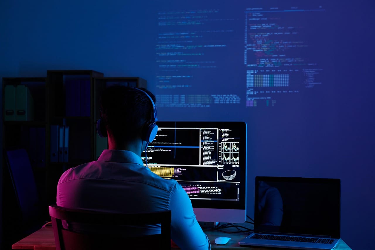 Operatore al computer con cuffie mentre lavora su software per call center inbound in un ambiente tecnologico e moderno.